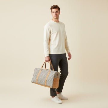 model holding a travel duffle bag